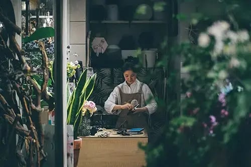 Einen Blumenladen eröffnen: Floristin in einem Blumenladen