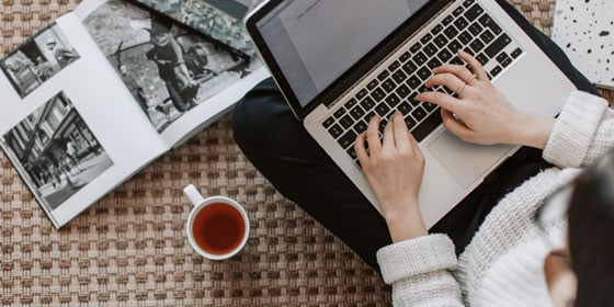 Arbeit am Computer auf dem Boden sitzend